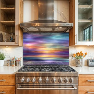 May include: A stainless steel gas range with a colorful glass backsplash featuring a sunset scene in shades of purple, blue, and yellow. The kitchen has wooden cabinets and a stainless steel range hood.