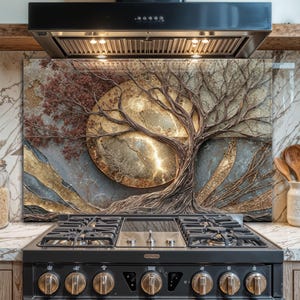 Puede incluir: Un protector contra salpicaduras de cocina decorativo con un diseño de árbol y un sol o luna dorada. El árbol tiene ramas y raíces marrones, con detalles en rojo y dorado. El fondo es una mezcla de tonos grises, dorados y azules.