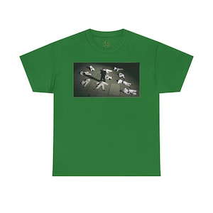 May include: A green t-shirt with a photo of a person standing over a group of people lying on the ground.