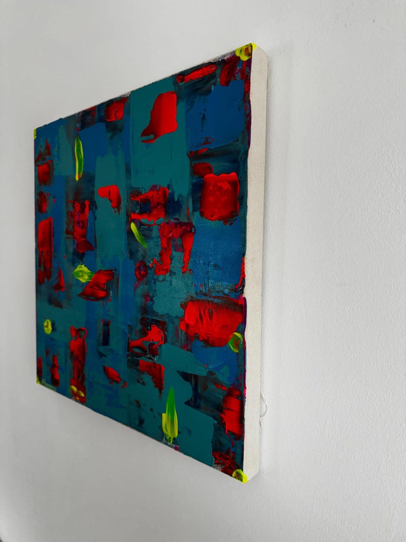 Puede incluir: Pintura abstracta acr&iacute;lica sobre lienzo con fondo turquesa, con trazos audaces de rojo, azul y verde. La obra est&aacute; montada sobre un bastidor blanco con bordes amarillos.