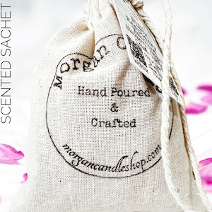 May include: A white cotton drawstring bag with a brown label that says "Morgan Candleshop.com" and "Hand Poured & Crafted".