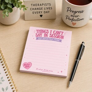 Op de afbeelding: Een lichtroze notitieblok met gelinieerd papier met de tekst 'THINGS I CAN'T SAY IN SESSION BUT DEFINITELY THINK' in roze en paars, een klein hartpictogram met het label 'Mental Note' en de zin 'It's not you. It's the session.' onderaan.