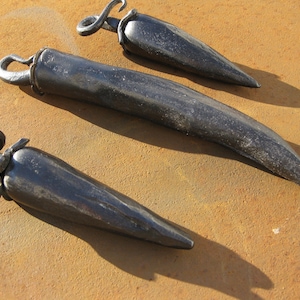 May include: Three black metal pepper shaped kitchen utensils with a loop handle.