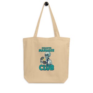 Peut inclure: Sac fourre-tout beige avec une anse noire. Le motif représente un squelette en costume tenant une tasse de café. Le texte "EXHAUSTED MANAGER CLUB" est imprimé en bleu sarcelle et blanc.