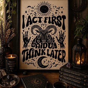 Peut inclure: Impression d'art encadrée noire avec le texte "I ACT FIRST I DIDUA THINK LATER" et une illustration de bélier. L'image est entourée de bougies, de livres, d'un journal et d'une tasse avec le texte "FOCUS ACTION RESULTS".