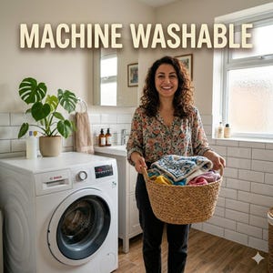 May include: A white Bosch washing machine with a black door and control panel. The text "MACHINE WASHABLE" is at the top of the image. A person is holding a basket of clean laundry in a bathroom.