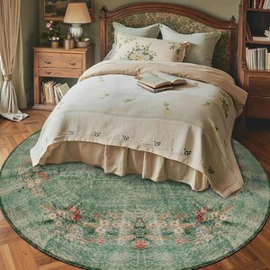 May include: A bedroom scene featuring a round, distressed green rug with floral patterns. The rug is centered beneath a bed with a floral headboard and matching bedding. The room has a vintage, cozy aesthetic.