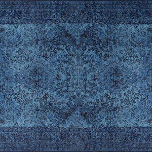 May include: A rectangular, distressed-look rug in shades of blue. The rug features a central field with a floral pattern and a darker blue border. The design has a vintage, faded appearance, suitable for home decor.