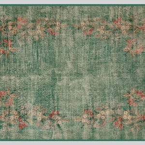 May include: A rectangular, distressed-look rug with a teal green background and a floral border. The border features pink and cream-colored flowers and foliage. The rug has a faded, vintage appearance, with a darker green border.