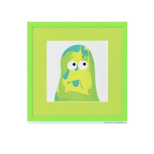 May include: A square framed print featuring a stylized, blob-like character with a marbled yellow and green body, two large white eyes with black pupils, and a small blue tongue. The artwork is encased in a bright lime green square frame.