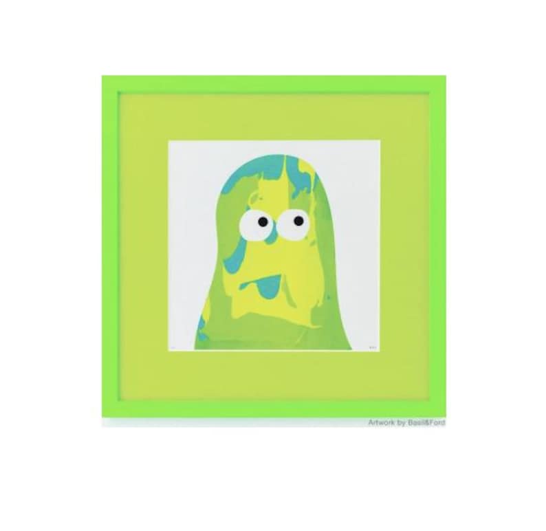 May include: A square framed print featuring a stylized, blob-like character with a marbled yellow and green body, two large white eyes with black pupils, and a small blue tongue. The artwork is encased in a bright lime green square frame.