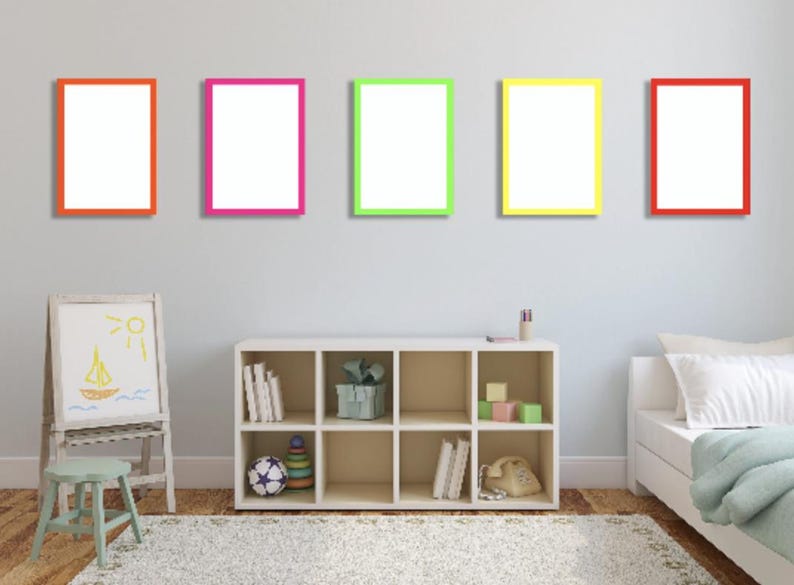 Five empty picture frames with colourful neon colours hang on a light grey wall. 
The frames are in a row, with the top of each frame aligned. The frames are orange, pink, green, yellow, and red. The frames are all the same size and shape.