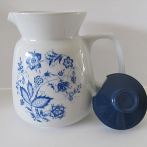 May include: White ceramic coffee pot with a blue floral design and a blue plastic lid.