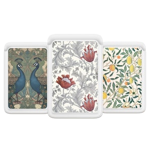 May include: Three rectangular tablet sleeves with white borders. The left sleeve features two blue peacocks among green foliage. The center sleeve displays red flowers and grey leaves on a cream background. The right sleeve shows yellow lemons.