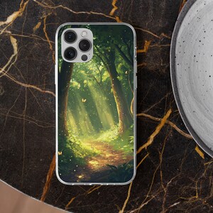 May include: A clear phone case with a colorful image of a forest path with sunlight streaming through the trees. The image features a green and brown forest with a path leading into the distance.