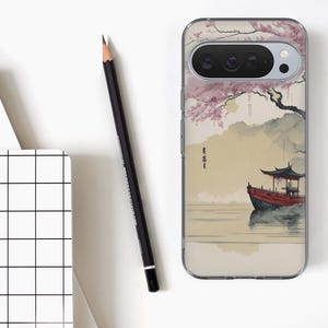 May include: Clear phone case featuring a Japanese-style painting of a red boat on water, with a pagoda and cherry blossom tree. The case has a black camera lens and a clear border. A black pencil and a notepad with a grid pattern are also in the image.