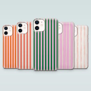 Puede incluir: Cinco fundas para teléfono con patrones de rayas verticales en varios colores. Las fundas presentan rayas en naranja, coral, blanco, rosa y verde. Las fundas son de plástico transparente y están diseñadas para un smartphone.