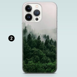 May include: A clear phone case with a foggy forest scene printed on the back. The forest is a dark green with a light mist.