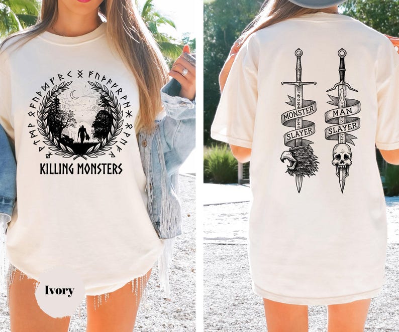 May include: Ivory-colored t-shirt with a front graphic featuring a forest scene, runes, and the text "KILLING MONSTERS." The back displays two swords with banners reading "MONSTER SLAYER" and "MAN SLAYER," along with a skull and eagle graphic.