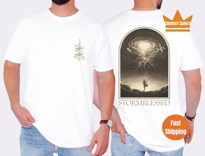Puede incluir: Camiseta blanca con un gr&aacute;fico de una persona de pie en un cielo tormentoso con el texto "Stormblessed" debajo. La camiseta tambi&eacute;n tiene un peque&ntilde;o gr&aacute;fico de una pancarta con el texto "Stormblessed" en ella.