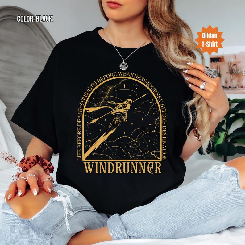 Puede incluir: Camiseta negra con un dise&ntilde;o dorado de una figura con una lanza y la palabra "WINDRUNNER". El texto alrededor del dise&ntilde;o dice "LIFE BEFORE DEATH &bull; STRENGTH BEFORE WEAKNESS &bull; JOURNEY BEFORE DESTINATION".