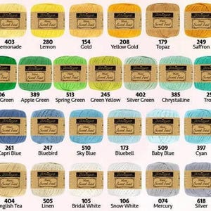 May include: A collection of yarn skeins in various colors, including shades of green, blue, yellow, and brown. Each skein has a label with a color name and number. The yarn is likely for knitting or crochet projects.