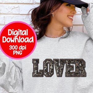 Puede incluir: Una sudadera gris claro con la palabra "LOVER" en un diseño de estampado de leopardo. La imagen también incluye un círculo rojo con las palabras "Digital Download 300 dpi PNG".