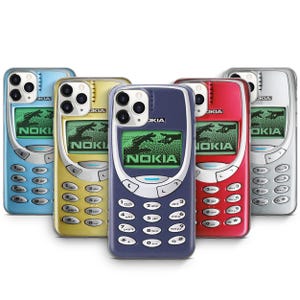 May include: Five different iPhone cases with a retro Nokia phone design. The cases are blue, yellow, dark blue, red, and silver. Each case features a pixelated image of a hand reaching out to grab a phone, with the word "NOKIA" displayed on the screen.