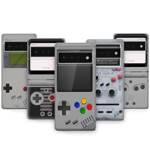 May include: A collection of five phone cases designed to resemble retro handheld gaming consoles. The cases are primarily gray with colorful buttons and directional pads. Some cases have transparent or semi-transparent designs, showcasing internal components.