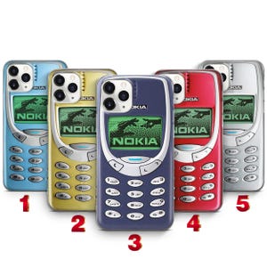 Pode incluir: Cinco capas para telemóvel com um design retro Nokia 3310 e um ecrã verde com a imagem de duas mãos a aproximarem-se. As capas estão disponíveis em azul claro, dourado, azul escuro, vermelho e prateado, com um recorte para a câmara no topo.