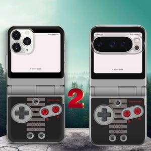 May include: Two clear smartphone cases featuring a retro video game controller graphic. The design includes a black and grey layout with red A and B buttons, the Nintendo logo, and text reading BATTERY FULL and START GAME on the upper section.