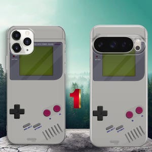 May include: Two light gray phone cases featuring a retro handheld gaming console design. Each case displays a dark gray screen area, a black directional pad, two purple A and B buttons, and gray Select and Start buttons with printed text.