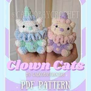 May include: A digital download PDF pattern for crocheting two clown cat amigurumi toys. One cat is blue, white, and green, and the other is pink, white, and purple. The pattern is by CalicoBayCrochet.