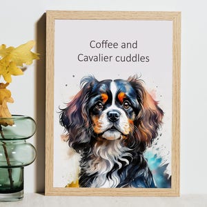 May include: A framed print featuring a watercolor painting of a Cavalier King Charles Spaniel. The dog has black, white, and brown fur. The text "Coffee and Cavalier cuddles" is above the dog. The frame is light brown.