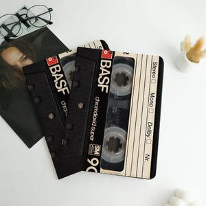 May include: Black cassette tape design with the BASF logo and "chromdioxid super 90" text. The tape has a clear window showing the tape inside. The design is on a black background with silver rivets.