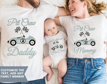 May include: White t-shirts and a baby onesie with a racing car design. The shirts say "Pit Crew Daddy" and "Pit Crew Mommy" with a race car graphic. The onesie says "Can't catch me I'm Two".