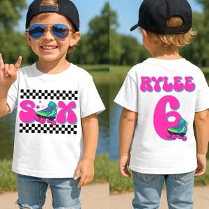 May include: White t-shirt with a roller skate graphic and the name "Rylee" and the number "6". The front of the shirt has a pink "S" and "X" with a roller skate design. The back of the shirt has the name "Rylee" and the number "6".