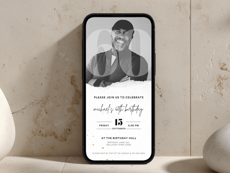 Puede incluir: Un tel&eacute;fono inteligente muestra una invitaci&oacute;n de cumplea&ntilde;os en blanco y negro. La invitaci&oacute;n presenta una foto de un hombre sonriente con el n&uacute;mero 60 superpuesto. El texto dice "Please join us to celebrate Michael's 60th birthday" con detalles de fecha y hora.