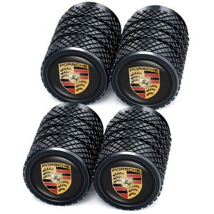 May include: Four black tyre valve stem caps with a textured design. Each cap features the Porsche logo in the centre, a shield with a horse and the word "Porsche" above it. The caps are designed for car tyres.