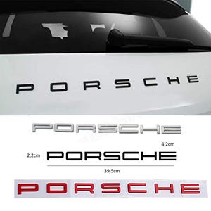 May include: Three different versions of the word "PORSCHE" in black, silver, and red lettering. The black lettering is on a white car, the silver lettering is on a white background, and the red lettering is on a white background with a white border. The measurements of the silver and red lettering are included in the image.
