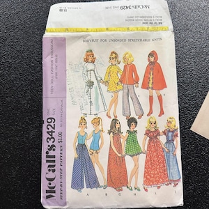 May include: Vintage McCall's 3429 sewing pattern for a teen doll trousseau. The pattern features illustrations of various outfits, including dresses, pantsuits, and a cape. The pattern is for a one size doll and includes the price.