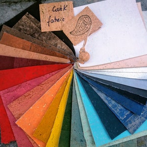 May include: A fan-shaped color chart of cork fabric samples in various colors, including red, orange, yellow, green, blue, and brown. The chart is labeled "Cork Fabric".