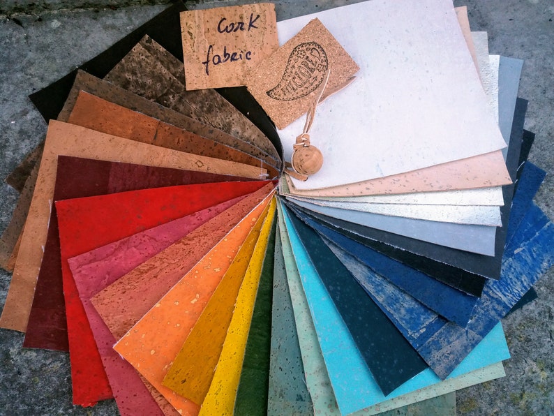 May include: A fan-shaped color chart of cork fabric samples in various colors, including red, orange, yellow, green, blue, and brown. The chart is labeled "Cork Fabric".