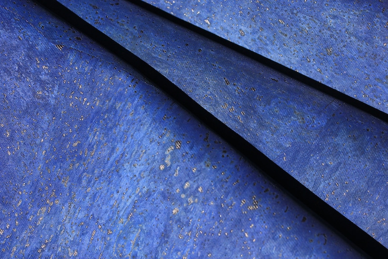 Peut inclure: Gros plan sur un tissu en li&egrave;ge bleu avec une subtile brillance. Le tissu est pli&eacute; en forme de triangle, cr&eacute;ant un fond textur&eacute;.