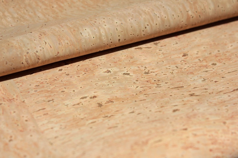 Pode incluir: Um close-up de uma folha de tecido de corti&ccedil;a natural de cor castanho claro e com um padr&atilde;o salpicado.