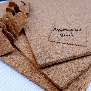 Może przedstawiać: Stos brązowych arkuszy korka z napisem "Agglomerated Sheet" na jednym z arkuszy.