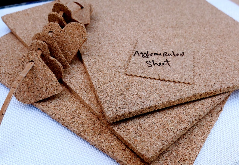 Może przedstawiać: Stos brązowych arkuszy korka z napisem "Agglomerated Sheet" na jednym z arkuszy.