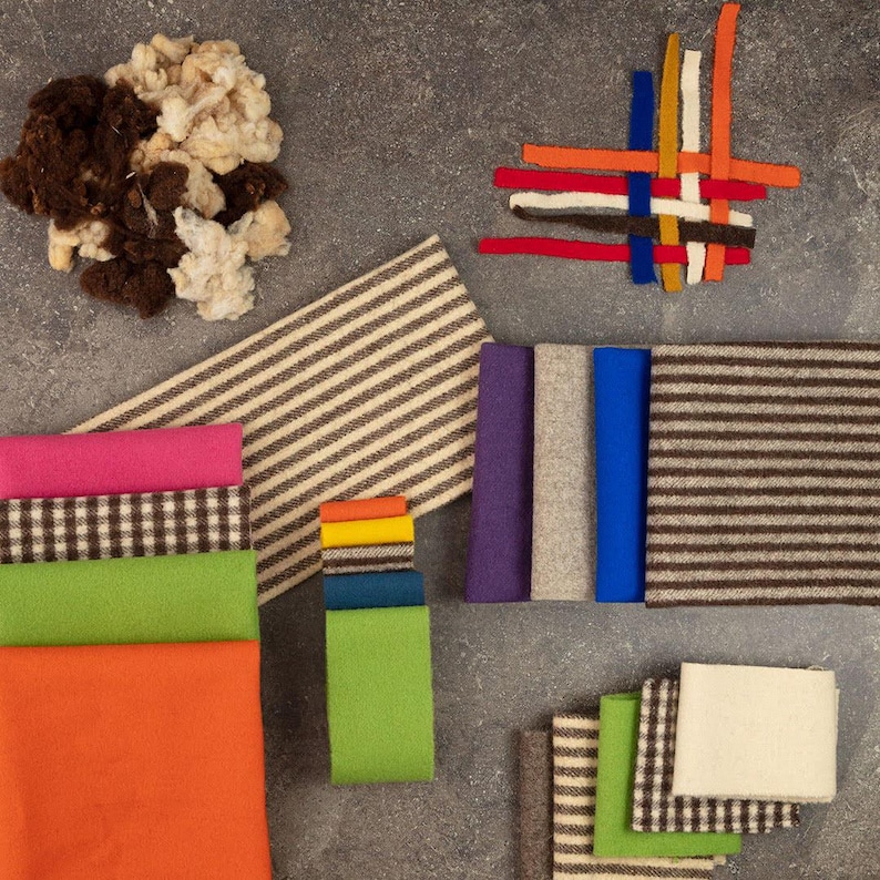 May include: A collection of textile materials including loose brown and cream wool fibers, various solid-colored fabric swatches in pink, green, orange, purple, gray, and blue, and several pieces of fabric featuring brown and cream striped or checkered patterns.