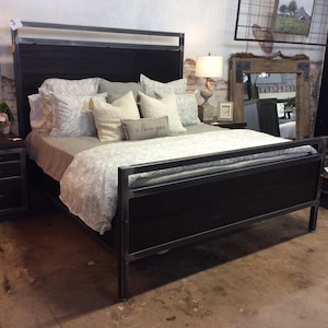 May include: A black metal bed frame with a wooden headboard and footboard. The bed is made up with white and gray bedding and a pillow with the text "I love you".