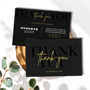 以下が含まれることがあります： 金色の文字が入った黒いサンキューカード。カードには、大きなフォントで「Thank You」という言葉が書かれています。カードには「For supporting my small business」というテキストとソーシャルメディアのアイコンも含まれています。カードは木製の表面にあります。